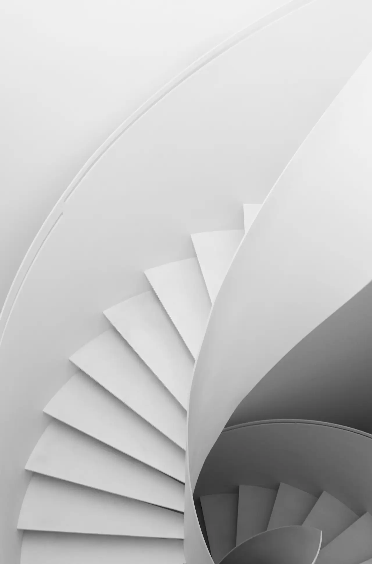 Minimale, weiße Wendeltreppe mit eleganten, geschwungenen Linien und sanften Schatten.