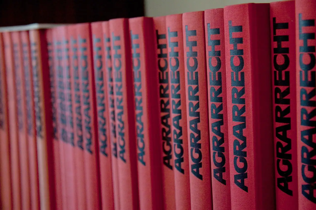 Reihe roter juristischer Fachbücher mit dem Titel Agrarrecht auf einem Regal