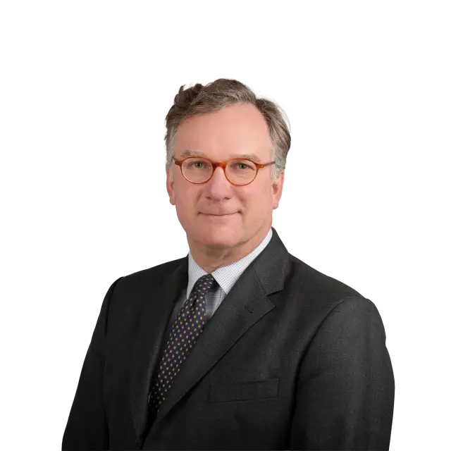 Porträt von Anwalt John Booth in dunklem Anzug, gestreifter Krawatte und runden Brillen.