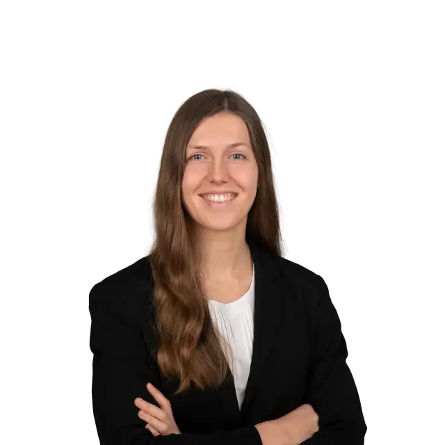 Isabelle Brozio, Anwältin, lächelt freundlich im schwarzen Blazer mit verschränkten Armen.