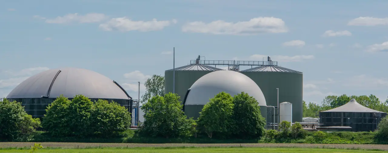 Biogasanlage mit mehreren großen Kuppeln und Silos in ländlicher Umgebung