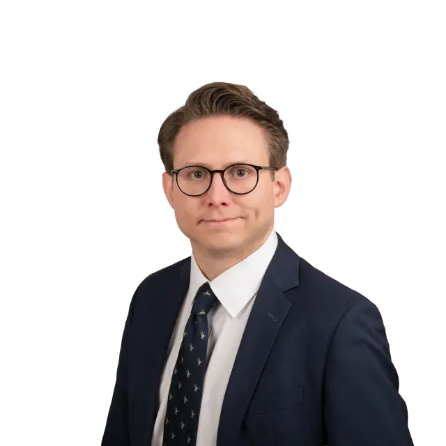 Porträt von Rechtsanwalt Mandus Fahje in dunklem Anzug, weißem Hemd und gemustertem Krawatte.