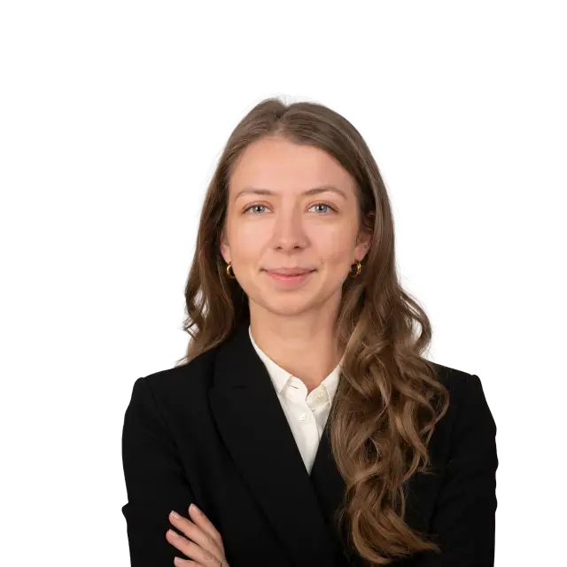 Nathalie Scheiblich, Anwältin, lächelt freundlich im schwarzen Blazer mit verschränkten Armen.