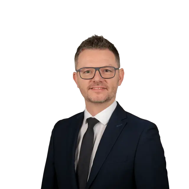 Porträtfoto von Rechtsanwalt Carlo Thiel im dunklen Anzug mit Krawatte und Brille