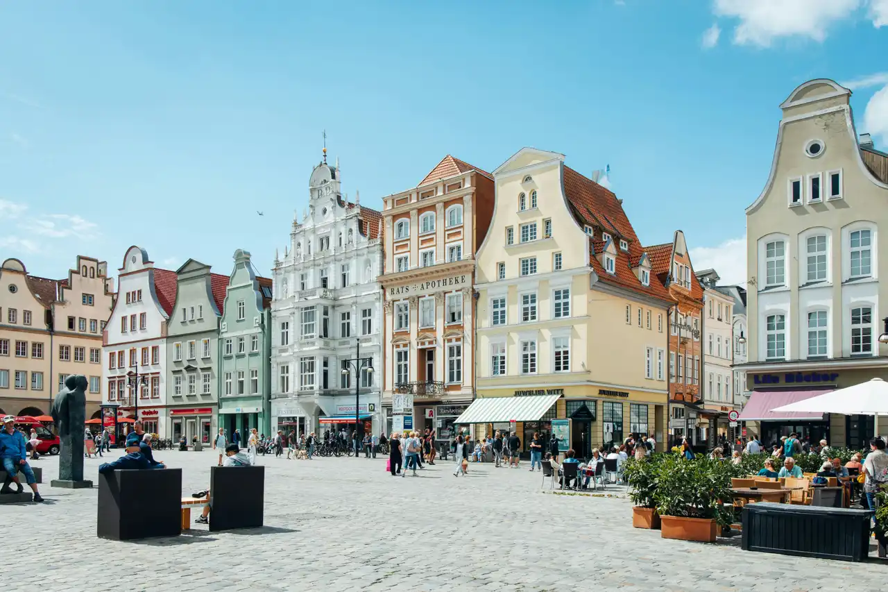 Neuer Markt in Rostock mit Cafés und zahlreichen Passanten an einem sonnigen Tag
